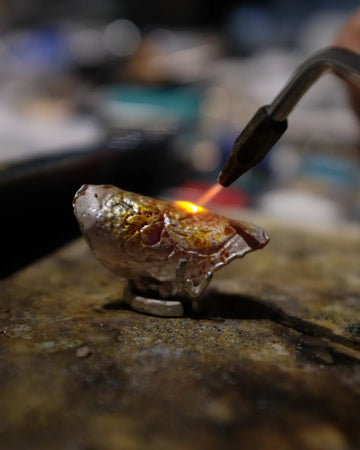 Molten 925 sterling silver heated by a torch during AOKINSIDE's small-batch jewelry casting process.